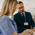 consultant with clipboard talking to colleague