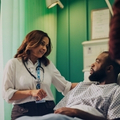 Doctor talking to patient in hospital bed