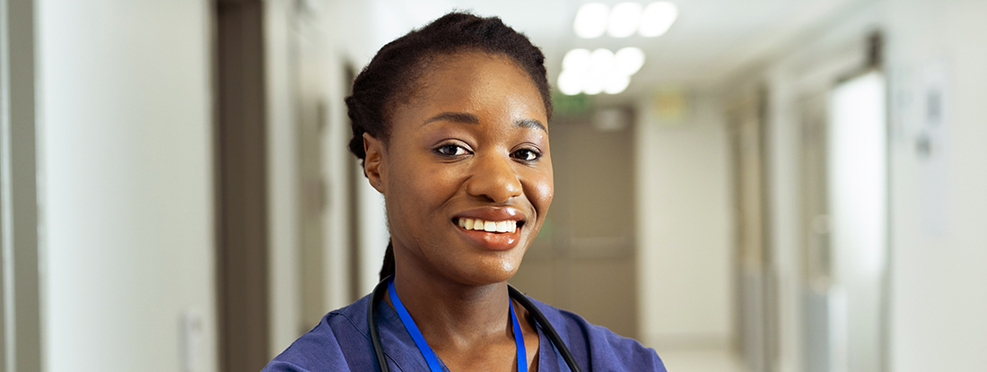 Doctor in hospital corridor smiling at the camera