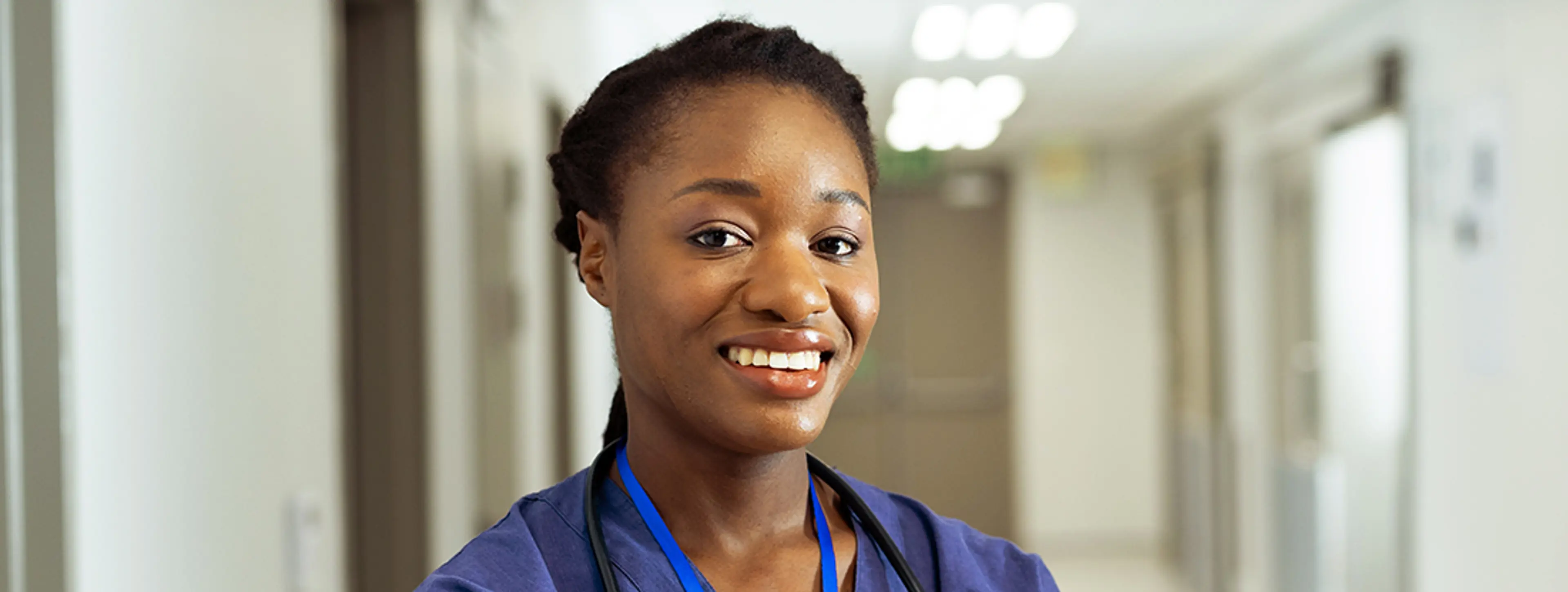 Doctor in hospital corridor smiling at the camera